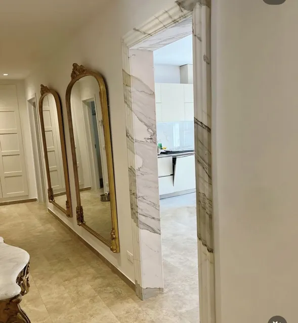 Corridoio con specchi e ingresso della cucina rivestito in marmo